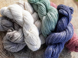 Skeins of SUSTAINALBE CASHMERE yarn in three undyed colors, and three hand-dyed choices